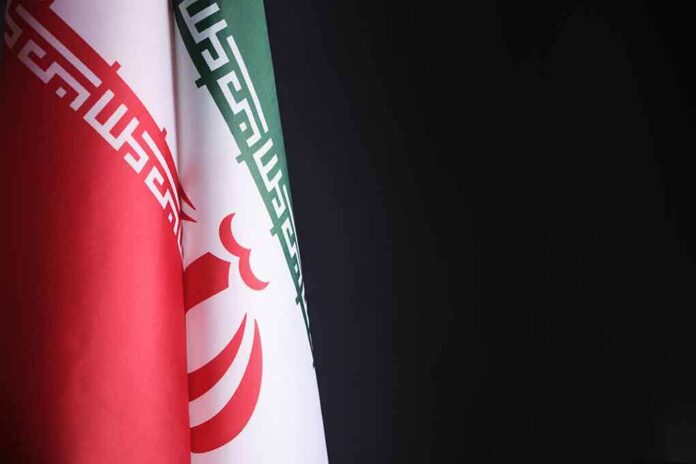 shutterstock_2075807950 Iran flag close-up on dark background
