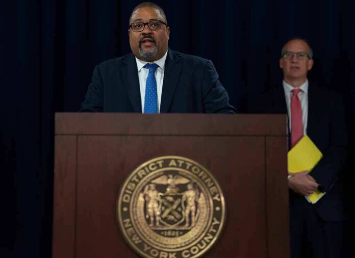 shutterstock_2199567225 Man speaks at podium with New York County District Attorney seal
