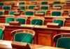 UK Lords Greenlight Cloned Voice – Big Shift Empty legislative chamber with green upholstered chairs and wooden desks