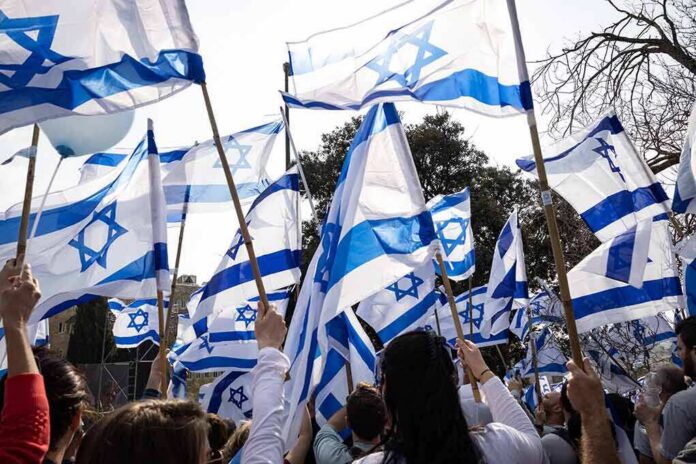 shutterstock_2264581927 Crowd waving Israeli flags outdoors