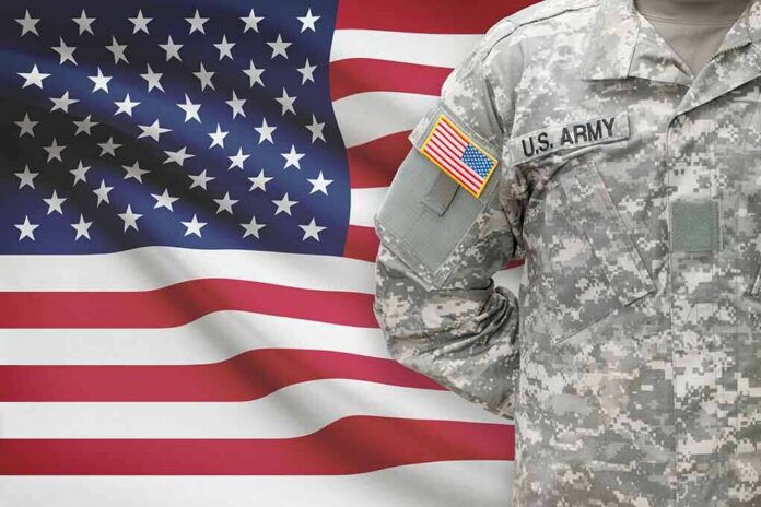 U.S. Army soldier in camouflage uniform before American flag