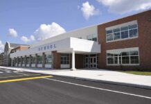 Religious Rights Clash – District Pays Up Modern school building with large windows and a clear sky