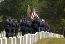Fort Bragg Exercise Tests Battlefield Burial Procedures Military honor guard marches through a cemetery with flags