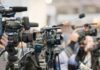 White House Access War Sparks DOJ Probe Video cameras on tripods at a press event