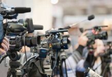 White House Access War Sparks DOJ Probe Video cameras on tripods at a press event