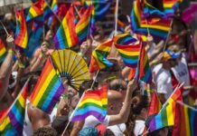 Hate Law Clash Erupts Over Rainbow Flyer Dontrelle Inman among crowd waving rainbow pride flags